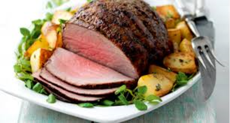 carved roast beef on a plate with roast potatoes