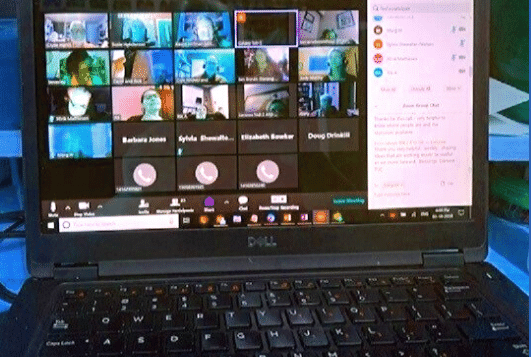 laptop with several people on screen in zoom meeting