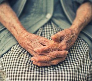 hands of old woman folded in her lap