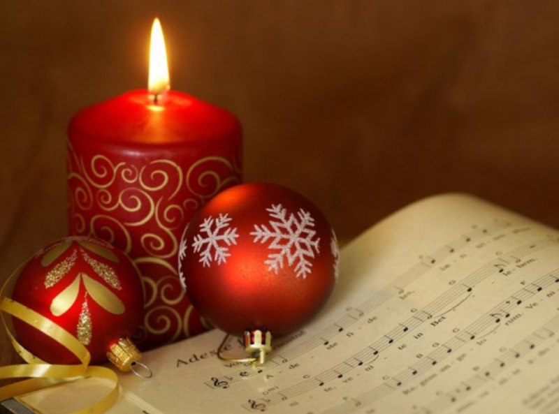 red candles and ornaments on a piece of sheet music