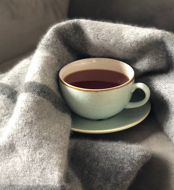 cup of tea in blanket on chair